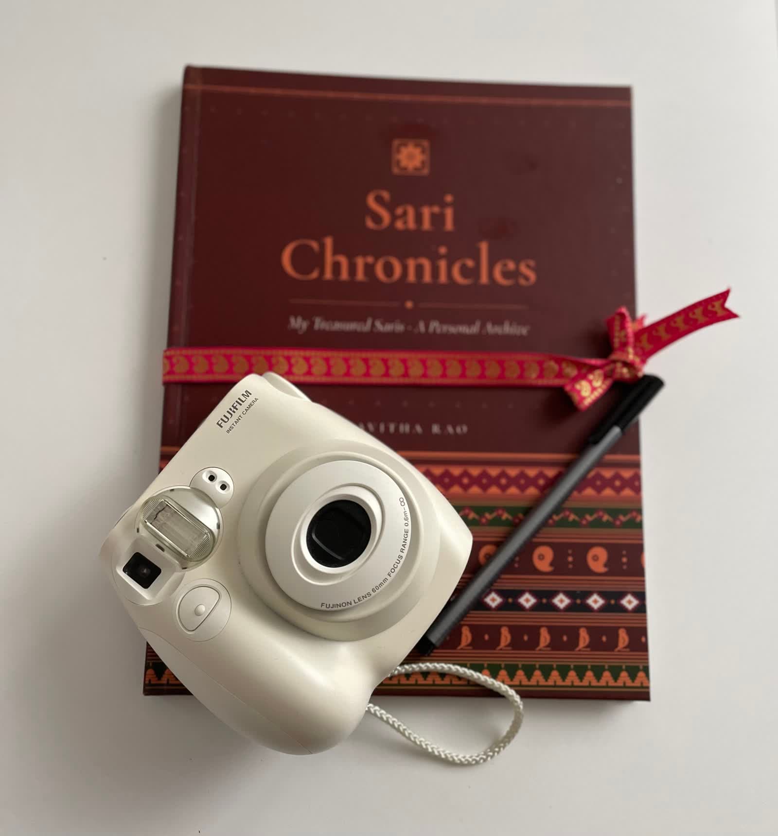 The book cover with an instant camera and a pen resting on it